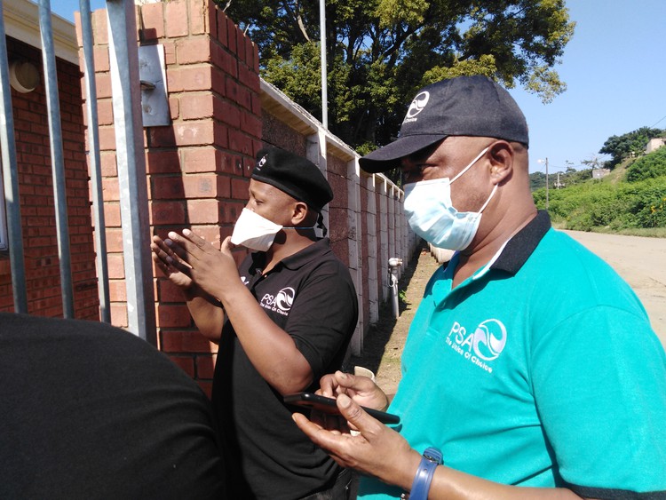 Photo of the two men standing outside the hospital