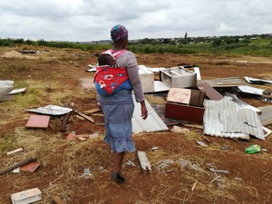 Photo of mother and child overlooking destroyed shack