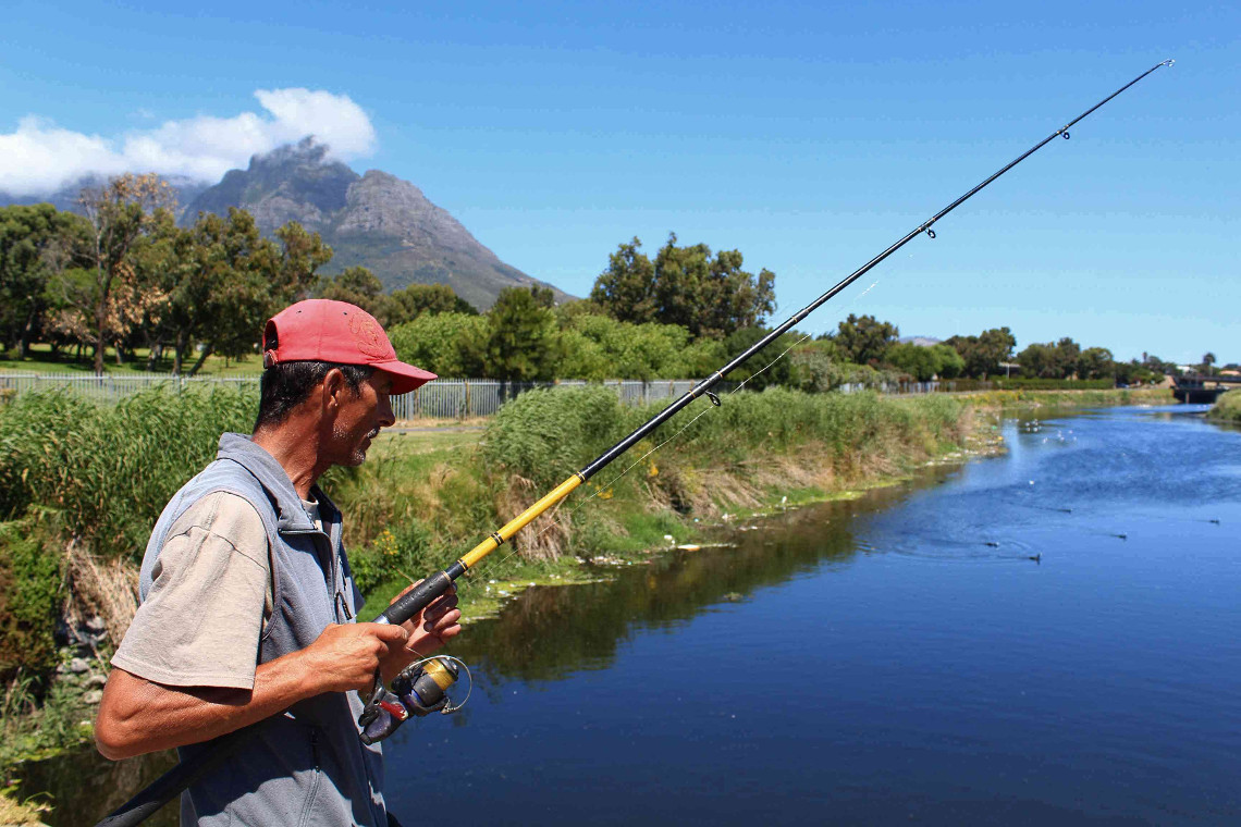 Wayne Wilke looks for fish to catch from the top of a bridge that runs across the Black River.