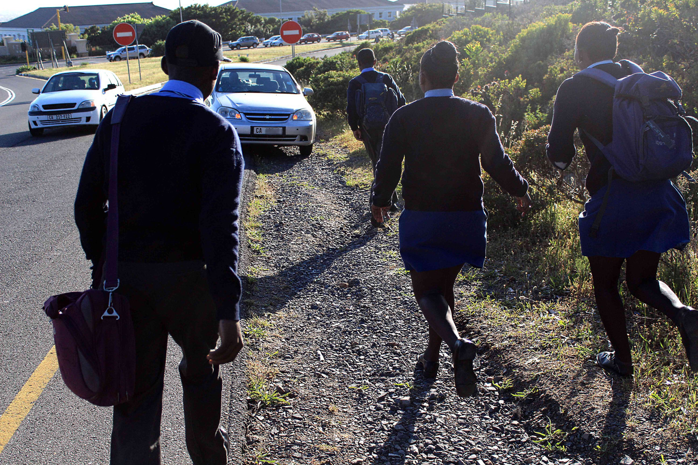 A car stops to pick up school students. But often they have to pay for lifts.