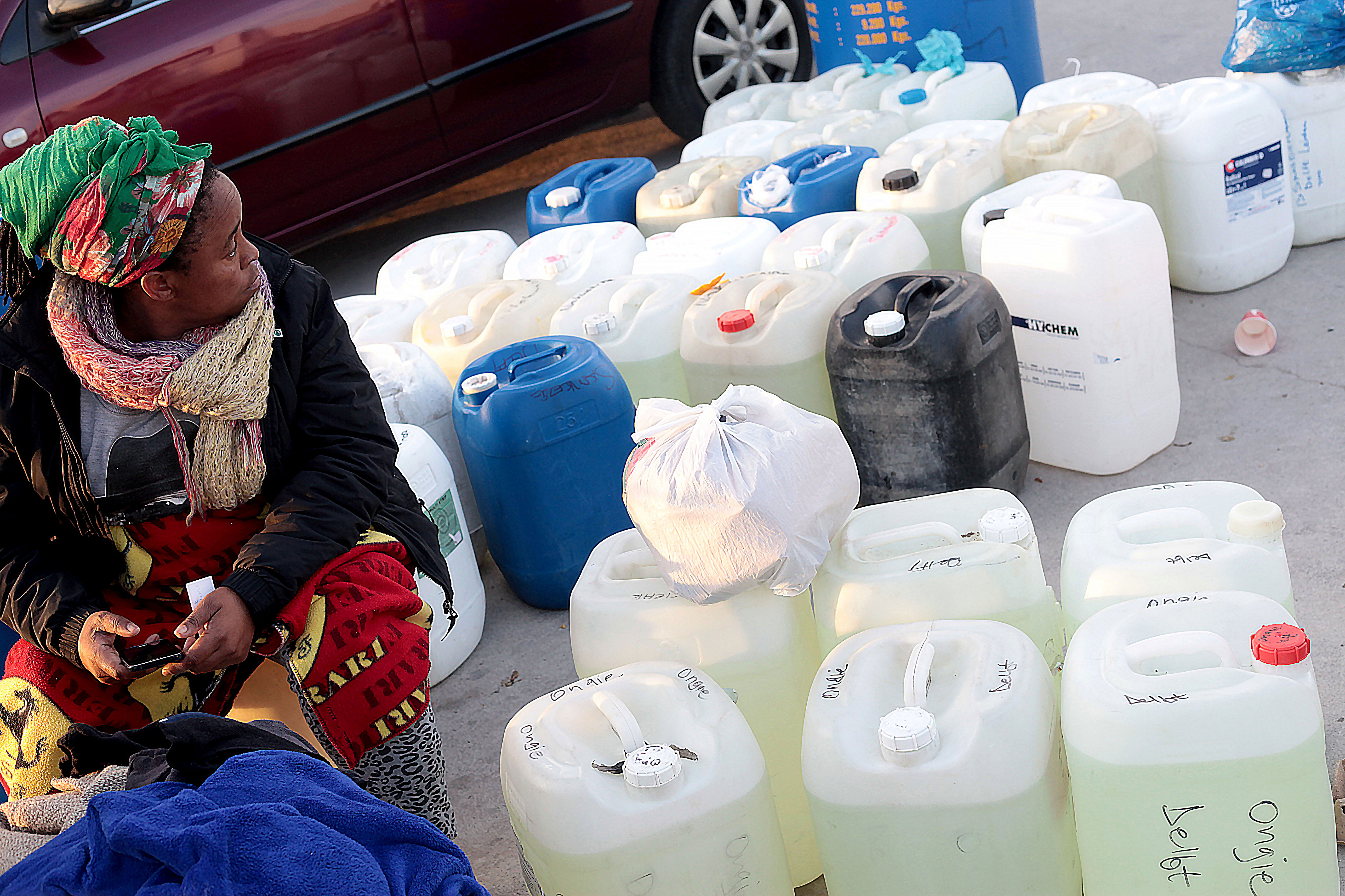 Photo of a woman sitting with plastic drums