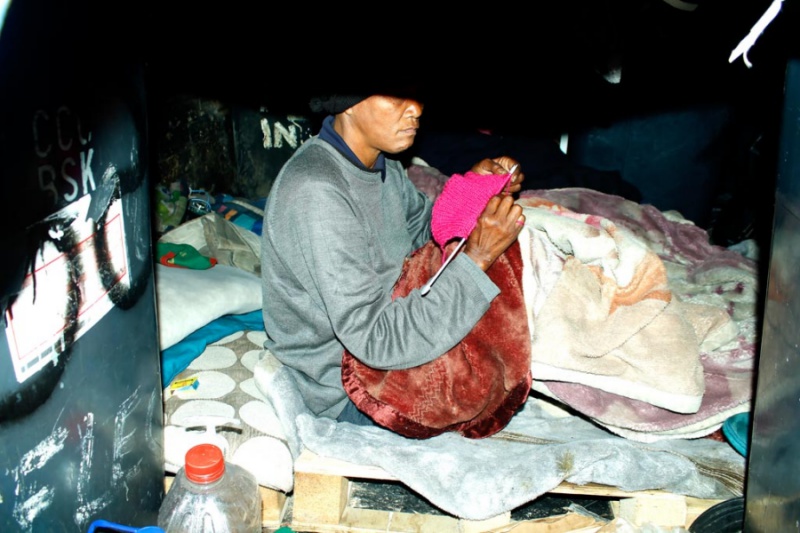 A homelss women swowing a top while sitting on her bedding woodstock _8189.jpg